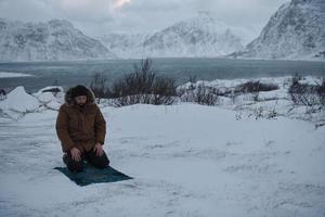 voyageur musulman priant dans une froide journée d'hiver enneigée photo