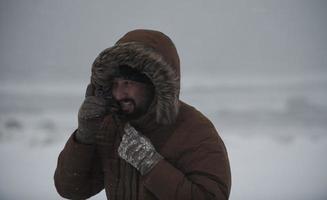 homme en hiver par temps orageux portant une veste de fourrure chaude photo