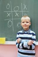 heureux jeune garçon aux cours de mathématiques de première année photo