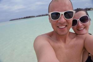 heureux jeune couple en vacances d'été s'amuser et se détendre à la plage photo