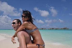 heureux jeune couple s'amuser sur la plage photo