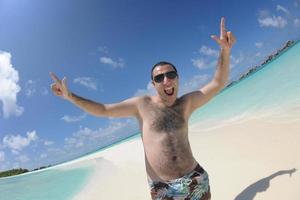 jeune homme s'amuser et se détendre sur la plage photo