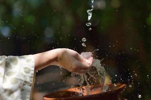 éclabousser de l'eau douce sur les mains de la femme photo