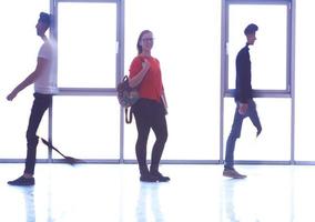 étudiante debout avec un ordinateur portable, groupe de personnes passant par photo