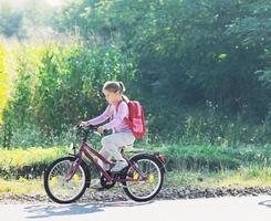 écolière se rendant à l'école à vélo photo