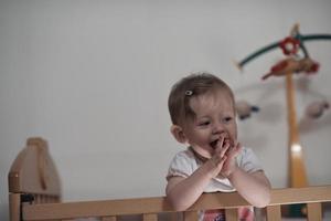 mignon petit bébé d'un an et faisant ses premiers pas au lit photo