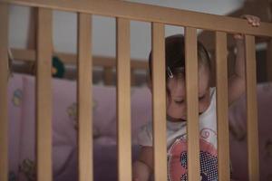 mignon petit bébé d'un an et faisant ses premiers pas au lit photo