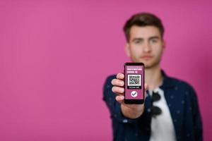 passeport covid, un jeune homme montre son code et son passeport covid sur son téléphone portable photo