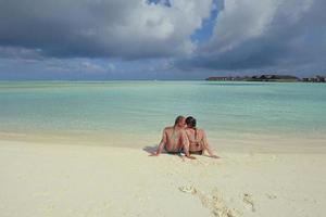 heureux jeune couple s'amuser sur la plage photo