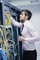 jeune ingénieur informatique dans la salle des serveurs du centre de données photo