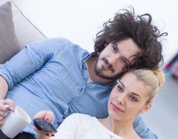 jeune couple sur le canapé devant la télévision photo