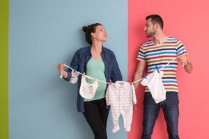 jeune couple tenant des combinaisons de bébé photo