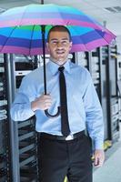 un homme d'affaires tient un parapluie dans la salle des serveurs photo