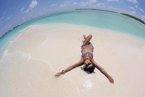 belle jeune femme sur la plage s'amuser et se détendre photo