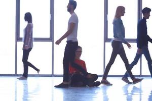 étudiante debout avec un ordinateur portable, groupe de personnes passant par photo