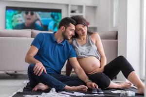 couple enceinte vérifiant une liste de choses pour leur bébé à naître photo