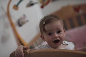 mignon petit bébé d'un an et faisant ses premiers pas au lit photo