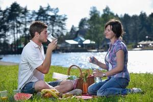 heureux jeune couple ayant un pique-nique en plein air photo