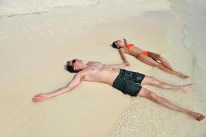 heureux jeune couple s'amuser sur la plage photo