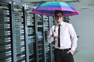 un homme d'affaires tient un parapluie dans la salle des serveurs photo