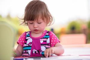 petite fille dessinant des images colorées photo