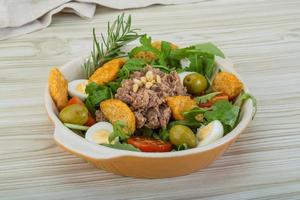 Salade de thon dans un bol sur fond de bois photo