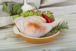 cuisse de poulet dans un bol sur fond de bois photo