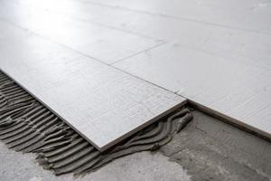 carreaux en céramique effet bois et outils pour carreleur au sol photo