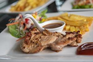 steak de poulet et salade de légumes dans un plat sur la table. photo