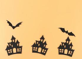décorations pour les vacances d'halloween, châteaux et chauves-souris sur fond orange avec espace de copie. photo