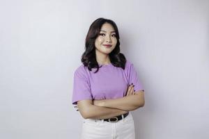 portrait d'une femme asiatique souriante confiante debout avec les bras croisés et regardant la caméra isolée sur fond blanc photo