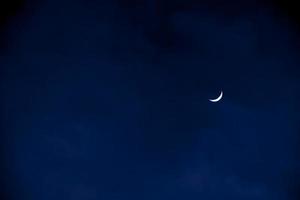 demi-lune en début de soirée sur ciel bleu foncé, photo