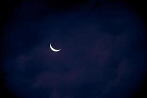 demi-lune en début de soirée sur ciel bleu foncé, photo