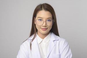 jeune femme ophtalmologiste avec des lunettes tenant un tableau des yeux sur fond bleu studio, concept de soins de santé photo