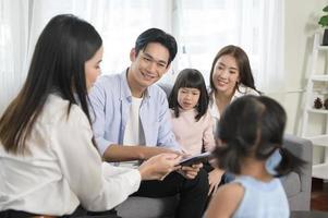 réunion de famille asiatique avec une femme agent immobilier ou consultant en assurance offrant des promotions, un prêt hypothécaire, un prêt, des biens et un concept d'assurance maladie. photo