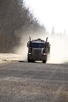 camion approchant sur une route étroite en hiver photo