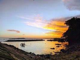 belle silhouette de coucher de soleil sur la plage photo