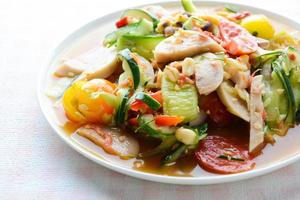 salade de concombre avec saucisses de porc conservées, nourriture populaire thaïlandaise appelée som tum tang, légumes chauds et épicés, mélangés.