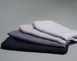 des piles de voiles de couleur nude soigneusement disposés sur un fond gris. mélange de tissu fin de couleur grise prêt à être utilisé pour les femmes musulmanes. peut également être utilisé pour les présentoirs de vente. flou de mise au point. hijab. photo