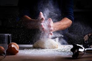 mains masculines faisant de la pâte pour la pizza, les boulettes ou le pain. notion de cuisson. photo