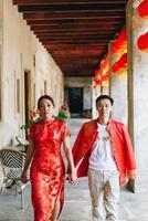 heureux jeune couple asiatique en robes traditionnelles chinoises photo