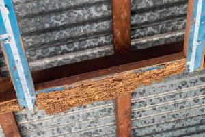 bois patiné de termites sous le toit en zinc de la maison. photo