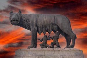 elle loup empire romain symbole allaitement nouveau-né romolus et remus statue sur fond de coucher de soleil rouge photo