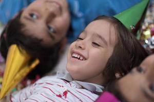 enfants soufflant des confettis allongés sur le sol photo