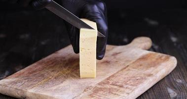 couper en morceaux du vrai fromage à pâte dure avec beaucoup de lait photo