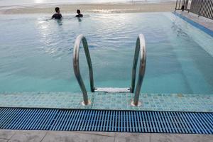 papouasie, indonésie - 10 octobre 2021. personnes nageant dans la piscine près de la mer photo