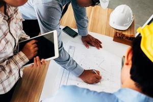 équipe d'ingénieurs discutant de l'esquisse du plan d'architecture sur le chantier de construction. photo