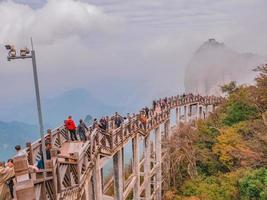 zhangjiajie.china - 15 octobre 2018.touristes inconnus marchant sur un pont en bois traversant la montagne dans le parc national de la montagne tianmen à zhangjiajie city china.landmark of hunan photo