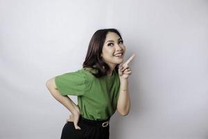 souriante belle femme asiatique pointant le doigt vers le côté pour vider l'espace isolé sur fond blanc photo