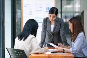 réunion de jeunes gens d'affaires asiatiques qui s'engagent à travailler. équipe commerciale créative assis à travailler ensemble au bureau. photo